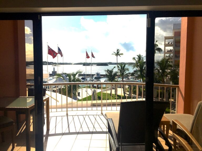 Never Forget Your Reading Glasses With this GenX Retires Vacation Packing List: A hotel balcony overlooks a Bermuda seaside resort